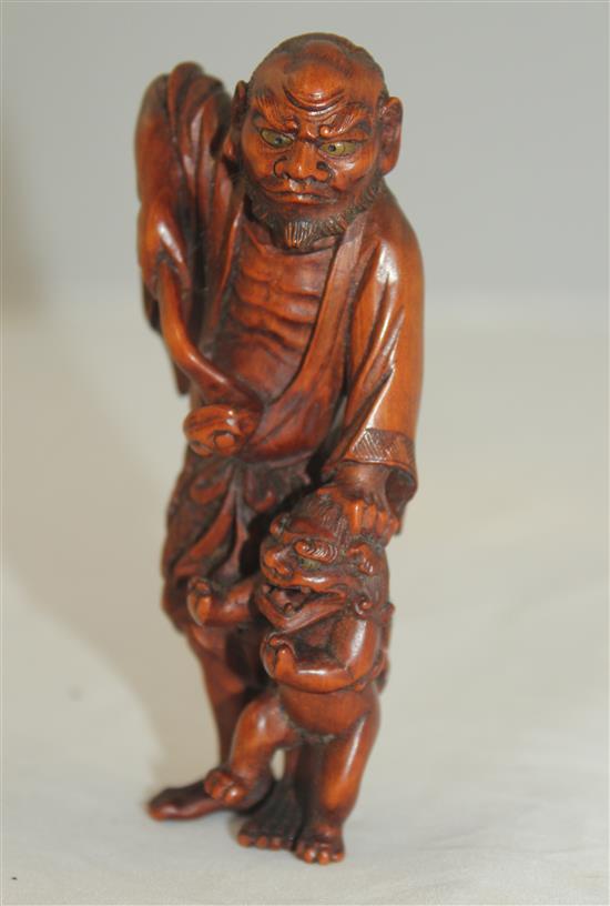 A Japanese boxwood okimono netsuke of a Sennin and a shi-shi, early 20th century, 10.5cm